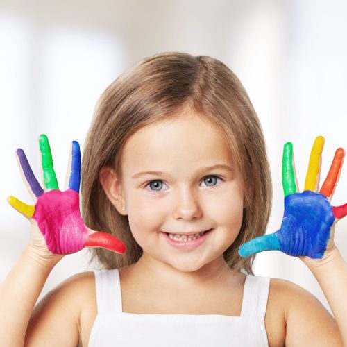 Cute little girl with colorful painted hands on  background